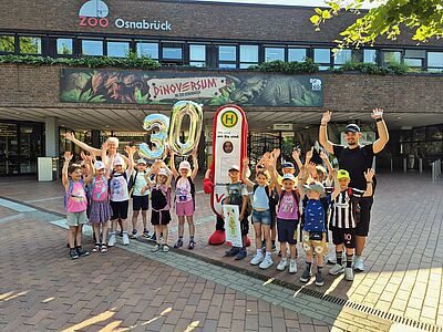 Gruppenfoto der Grundschule Wellingholzhausen mit Haltelinchen vor dem Zoo.