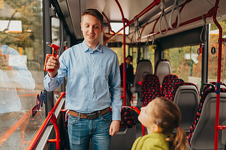 Der Bustrainer erklärt dem Mädchen, wie der Notfallhammer funktioniert.