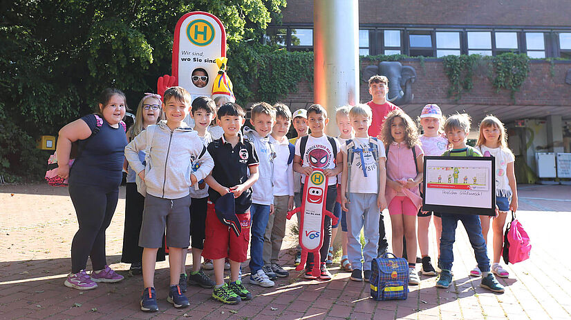 Die i - Männchen Grundschüler der Osnabrücker Rosenplatzschule stehen vor dem Eingang des Osnabrücker Zoos.