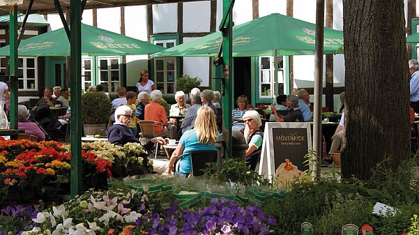 Sommerlicher Wochenmarkt mit Blumenständen auf dem Kirchplatz. 
