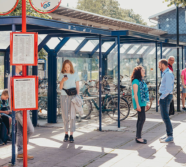Fahrgäste warten an Haltestelle im Südkreis auf den Bus